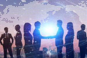 silhouettes of people shaking hands in front of a world map